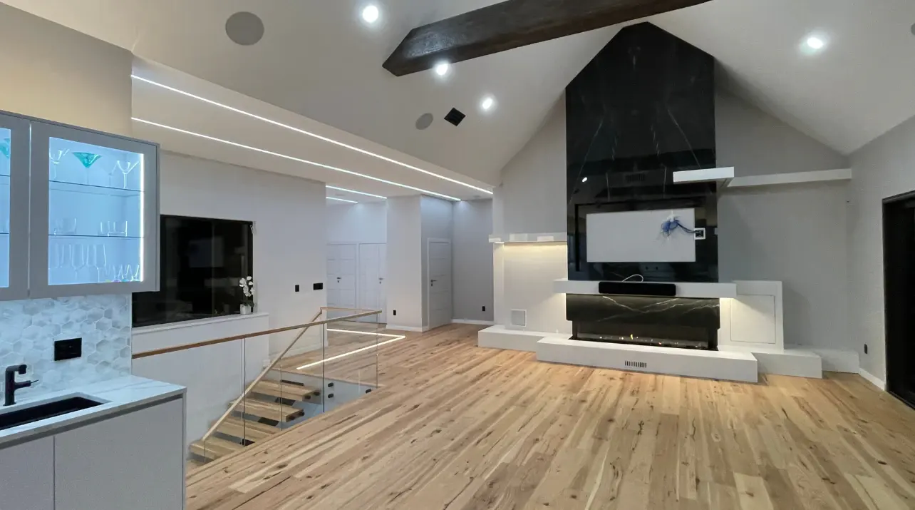 Newly finished wide-plank hardwood running the full width of a vaulted open-plan room