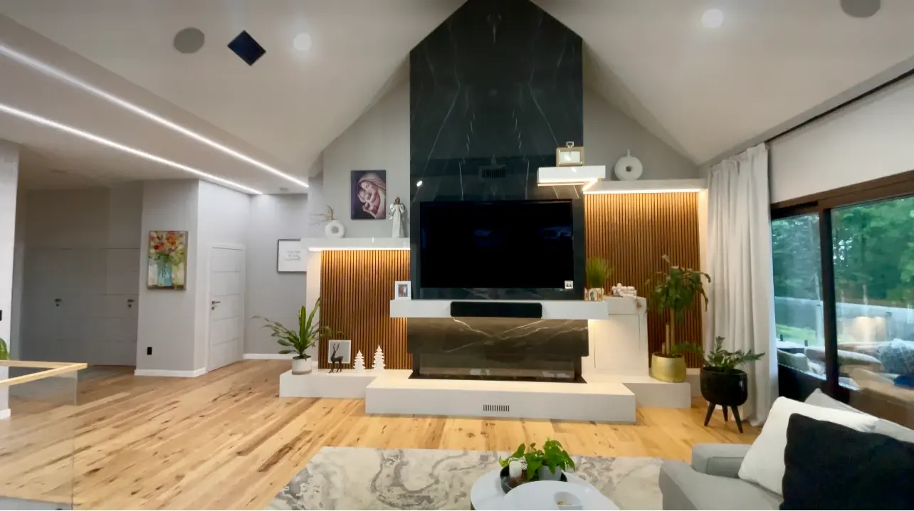 Living room with a wood-clad feature wall, linear fireplace and integrated shelving